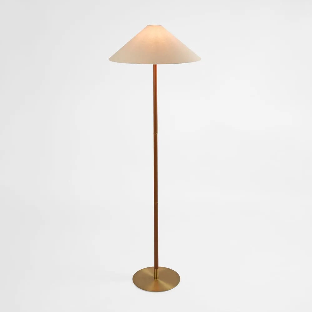 Elegant brass floor lamp with a slim, minimalist design and a wide conical fabric shade. The lamp features a sleek gold-tone metal base, offering a warm and sophisticated lighting solution for modern interiors.